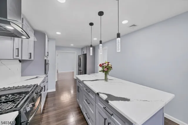 a kitchen with sink stove and wooden floor