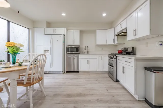 a kitchen with white cabinets and white appliances