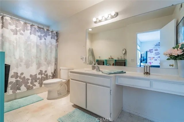 a bathroom with a double vanity sink toilet and a mirror