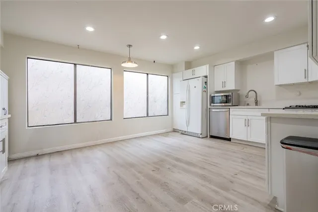 a view of a kitchen with a sink and dishwasher a refrigerator with wooden floor