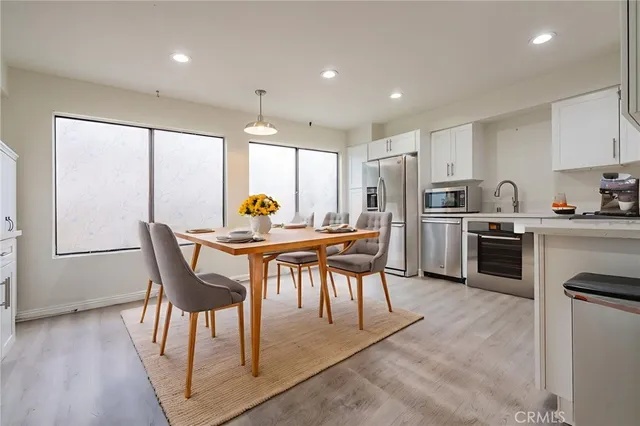 a kitchen with a table chairs refrigerator and microwave