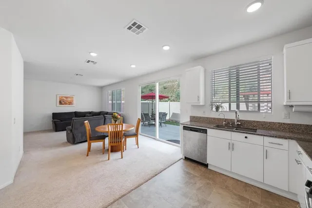 a living room with furniture and a view of kitchen