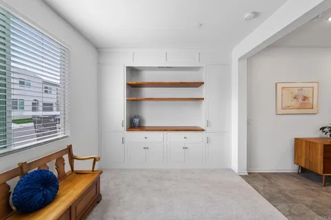 a view of staircase with lots of frames on wall and wooden floor
