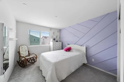 a bedroom with a bed and a refrigerator