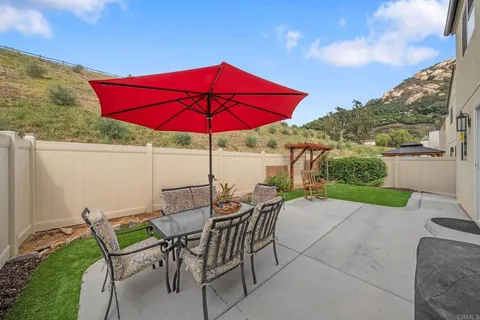 a view of backyard with table and chairs and potted plants