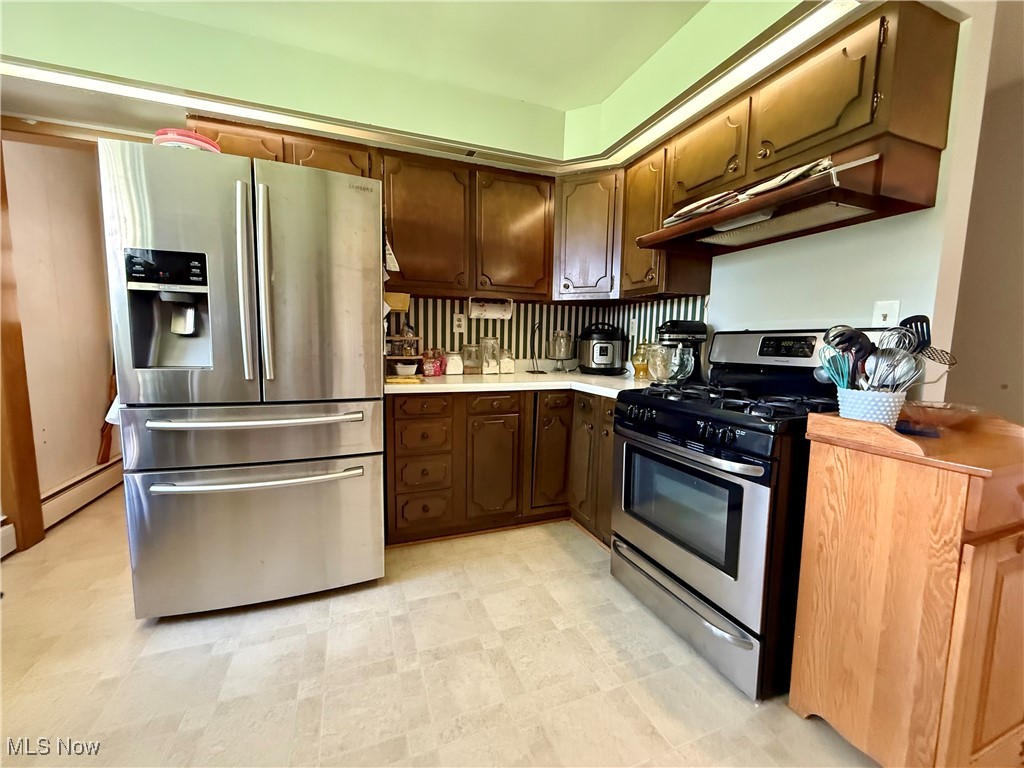248 Scio Road Carrollton, OH 44615 - Photo 5 of 33 Kitchen featuring appliances with stainless steel finishes, light countertops, a baseboard heating unit, and light floors