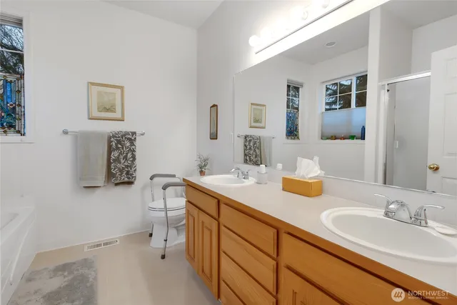 a bathroom with a sink double vanity granite and a toilet