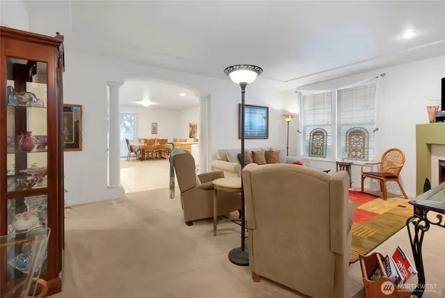 a living room with furniture a dining table and chairs next to a window