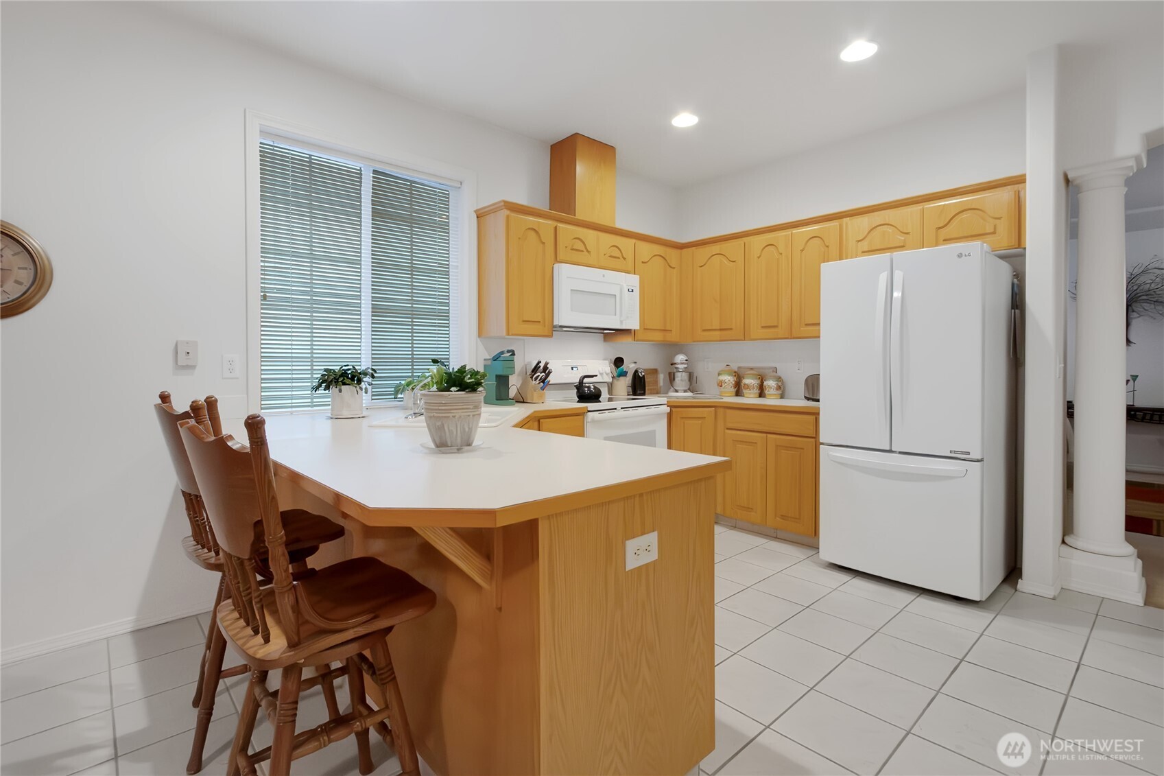 8235 Sweetbrier Loop Southeast Olympia, WA 98513 - Photo 9 of 24 a kitchen with a refrigerator a stove a sink and a dining table with wooden cabinet