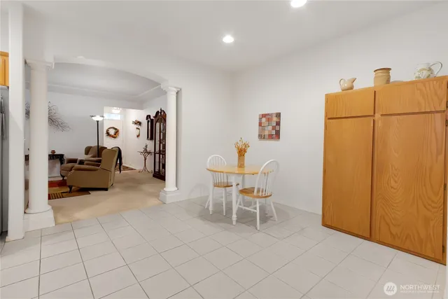 a living room with furniture a refrigerator and a table