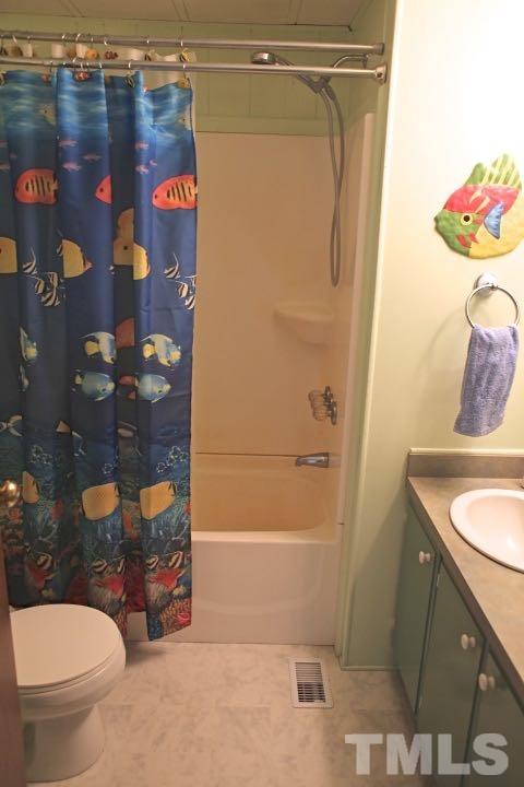 9566 George Ruff Road Bullock, NC 27507 - Photo 12 of 25 a bathroom with a granite countertop sink a toilet and a shower