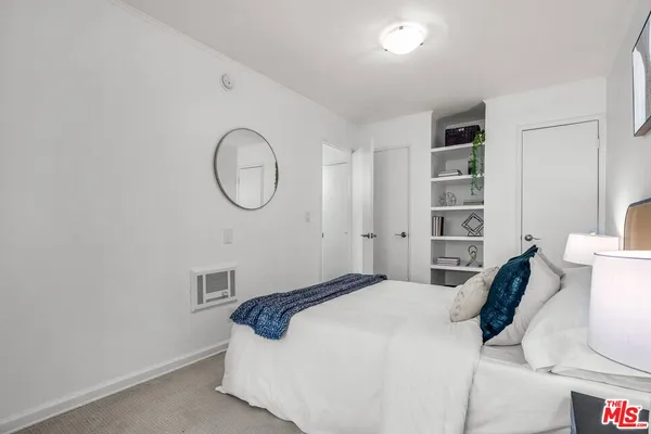 a bedroom with a bed and a potted plant