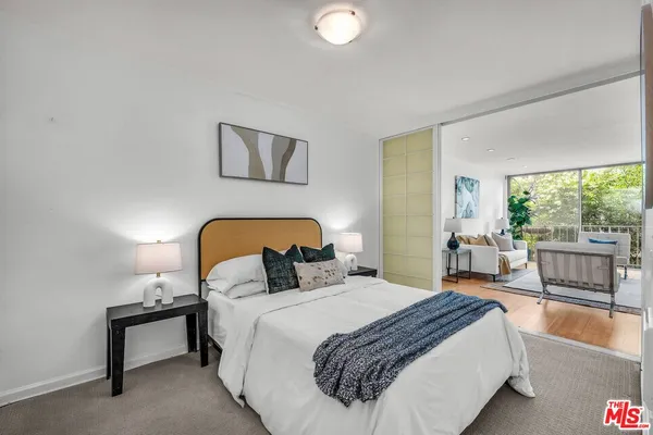 a bedroom with a bed and a large window with outer view
