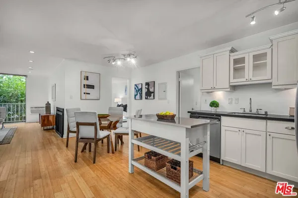 a view of kitchen with stainless steel appliances granite countertop a stove a sink a dining table and chairs