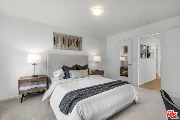 a spacious bedroom with a bed and a lamp