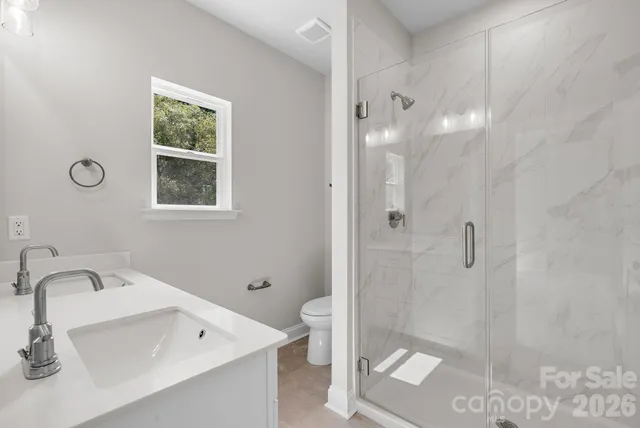 a bathroom with a sink a toilet and shower