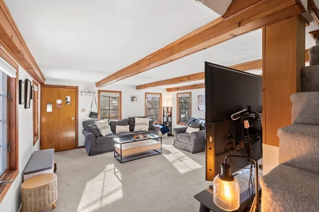 a living room with furniture a flat screen tv and a floor to ceiling window