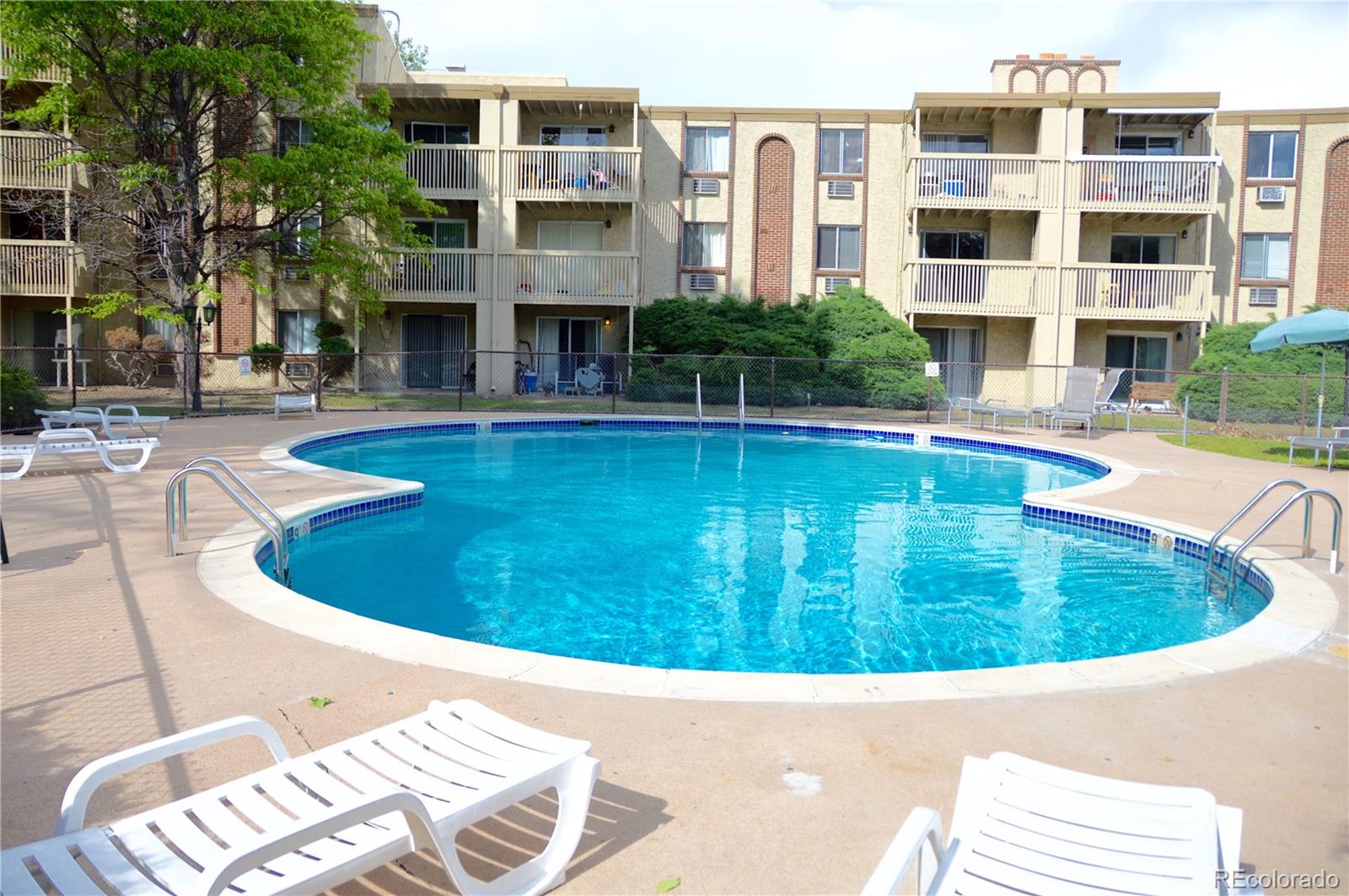 1302 South Parker Road, Unit 336 Denver, CO 80231 - Photo 2 of 9 a view of a swimming pool with a lounge chairs