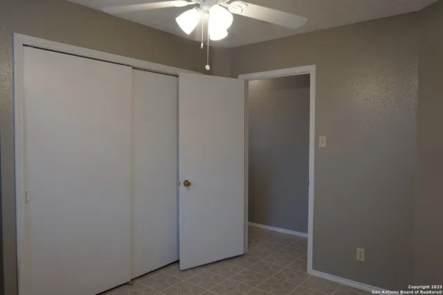 a view of a room with a chandelier fan