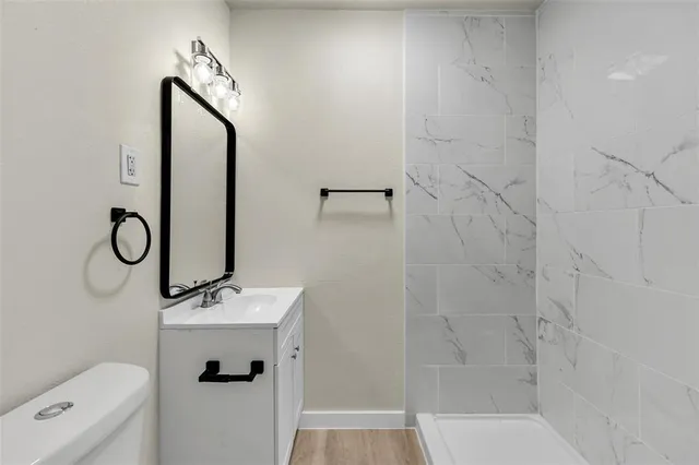 a bathroom with a sink a toilet and shower