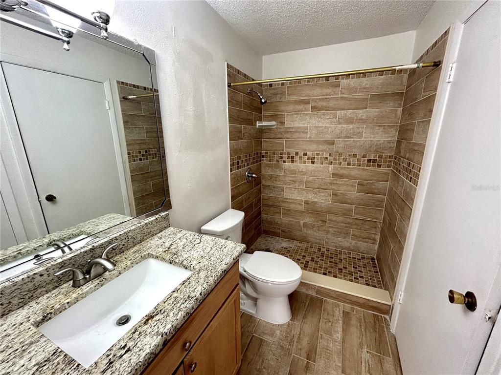 8758 Mallard Reserve Drive, Unit 102 Tampa, FL 33614 - Photo 14 of 17 a bathroom with a granite countertop sink toilet and shower