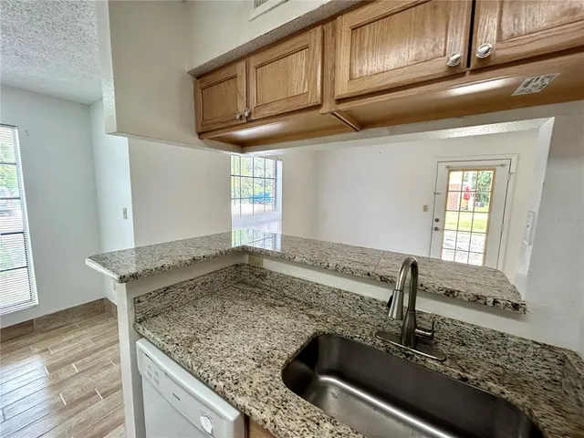 a kitchen with granite countertop a sink and a stove