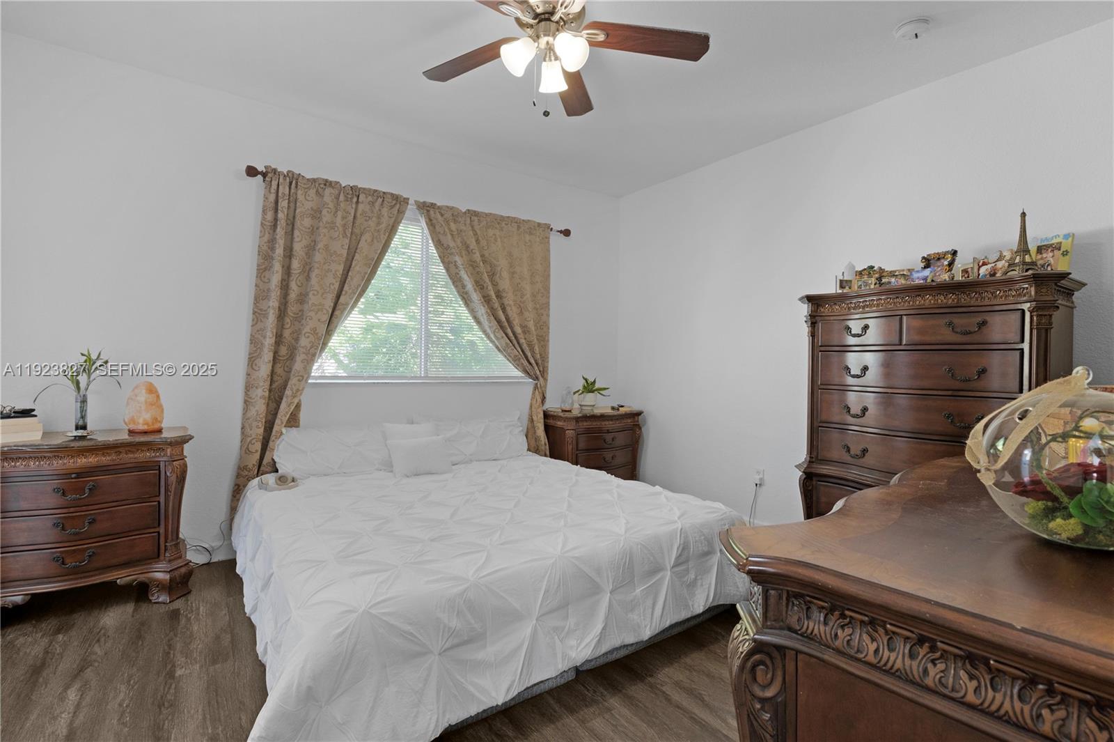 8525 Southwest 214th Terrace Cutler Bay, FL 33189 - Photo 16 of 35 a bedroom with a bed and a chandelier