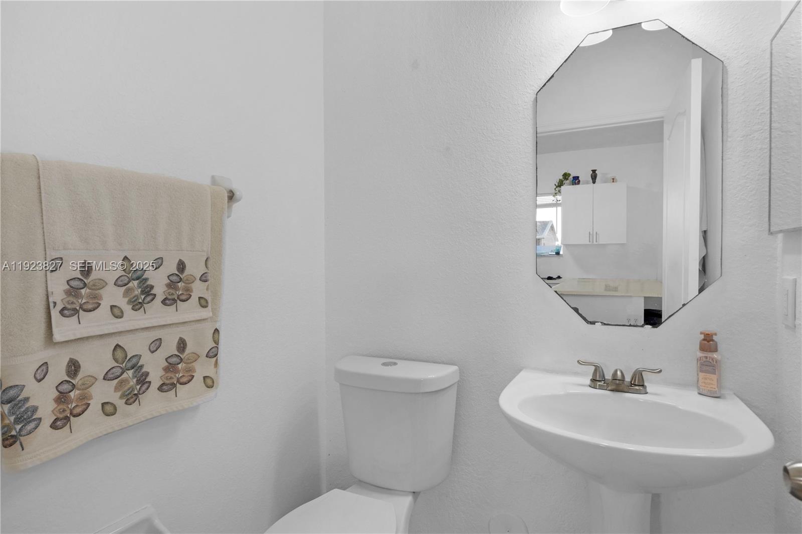 8525 Southwest 214th Terrace Cutler Bay, FL 33189 - Photo 23 of 35 a bathroom with a toilet sink and mirror