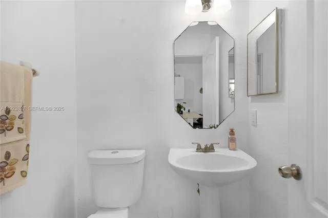 a bathroom with a sink a toilet and mirror
