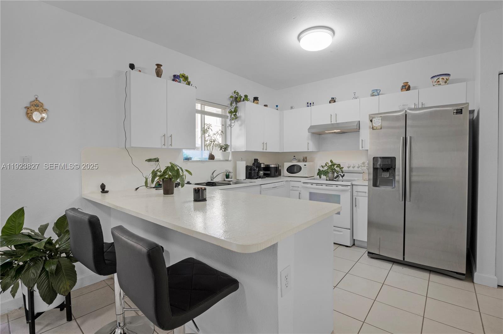 8525 Southwest 214th Terrace Cutler Bay, FL 33189 - Photo 26 of 35 a kitchen with stainless steel appliances a white counter top space cabinets and a potted plant