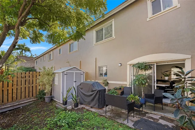 a view of a chair and table in backyard of the house