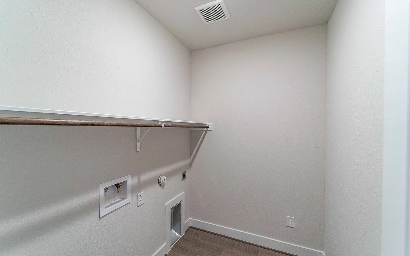 450 Durian Loop Buda, TX 78610 - Photo 16 of 17 A dedicated utility space, this laundry room features ample room for appliances and a convenient overhead hanging rod.