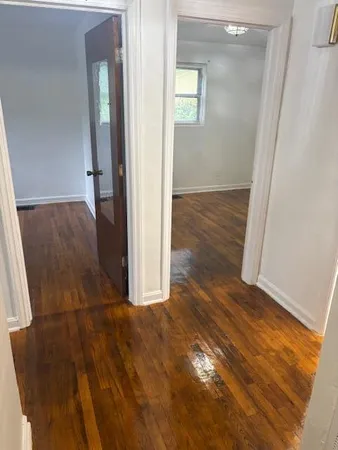 an empty room with wooden floor and entrance