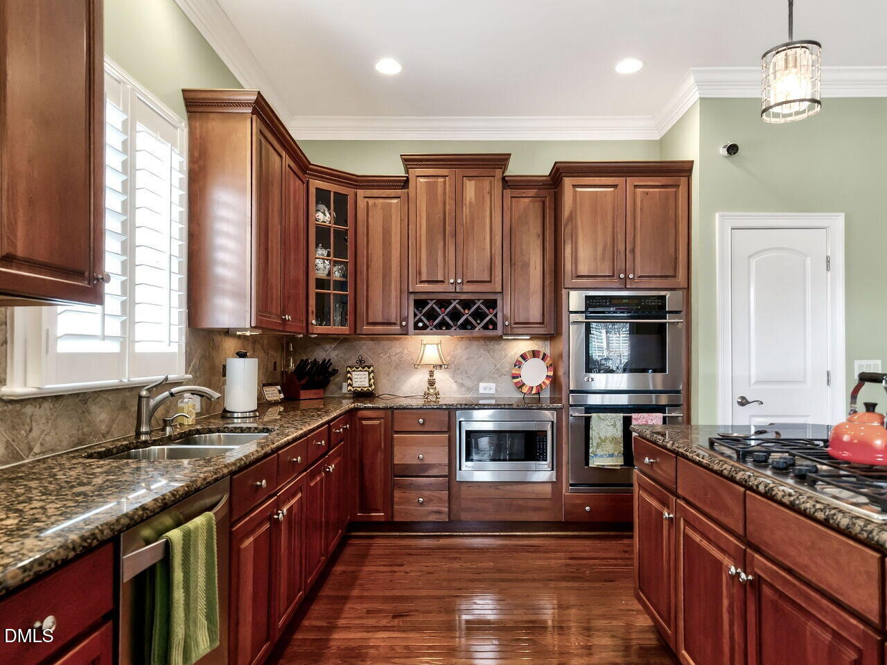8409 Passage Marseille Court Raleigh, NC 27615 - Photo 10 of 48 a kitchen with kitchen island granite countertop a sink stove and cabinets