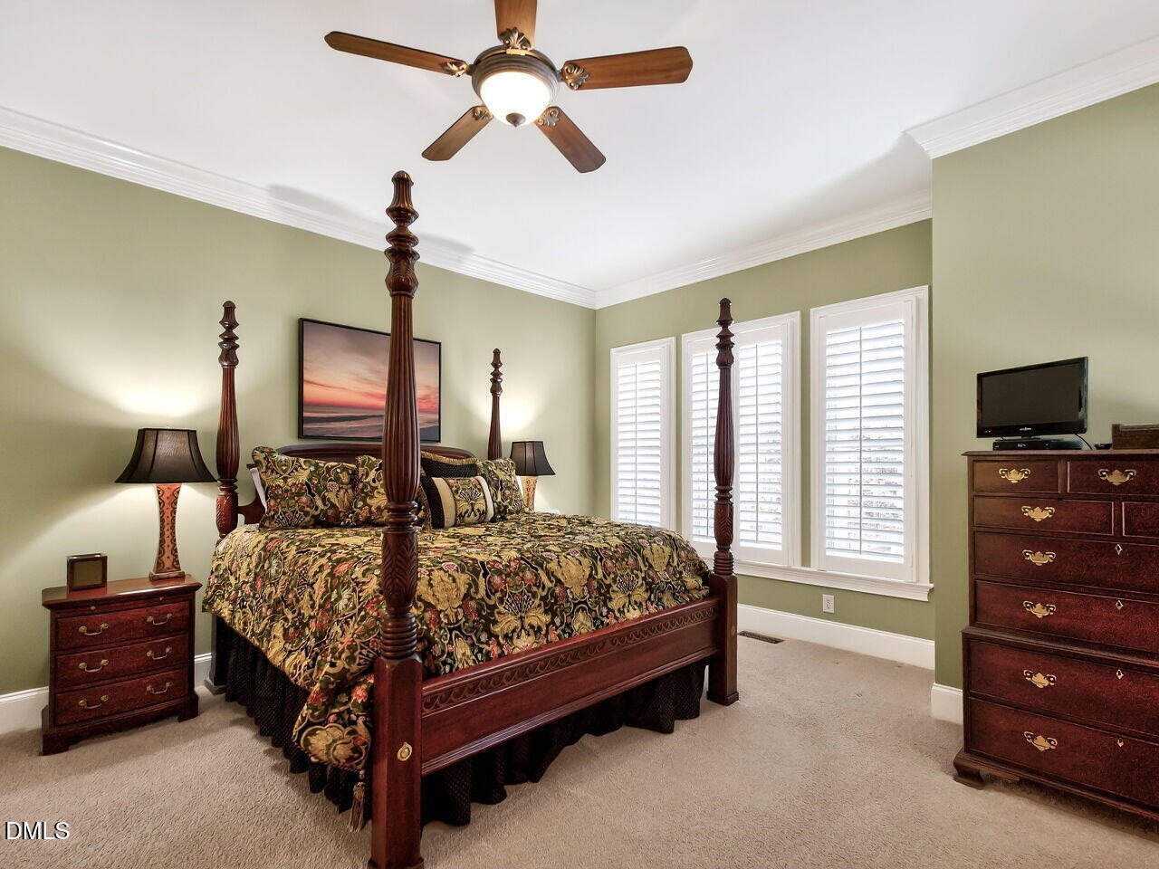 8409 Passage Marseille Court Raleigh, NC 27615 - Photo 22 of 48 a bedroom with a bed a chandelier and a flat tv screen on dresser