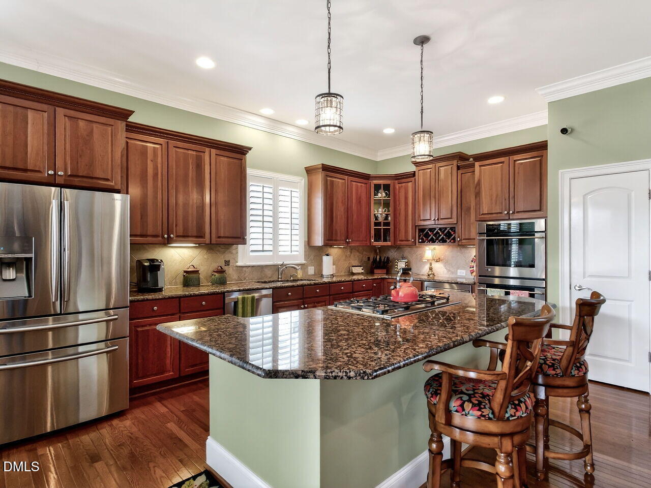 8409 Passage Marseille Court Raleigh, NC 27615 - Photo 8 of 48 a kitchen with stainless steel appliances granite countertop a sink a stove a refrigerator cabinets and chairs
