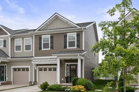 a front view of a house with plants and entryway