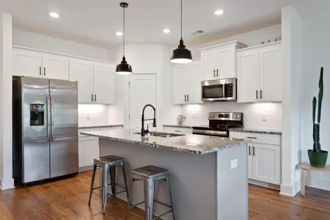 a kitchen with kitchen island a counter space a sink appliances and cabinets