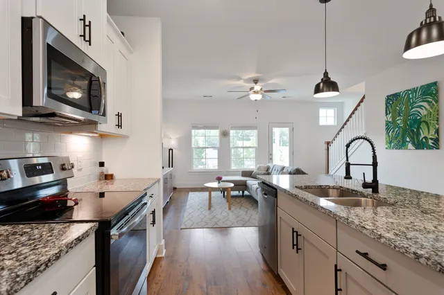 a kitchen with lots of counter top space a sink appliances and cabinets