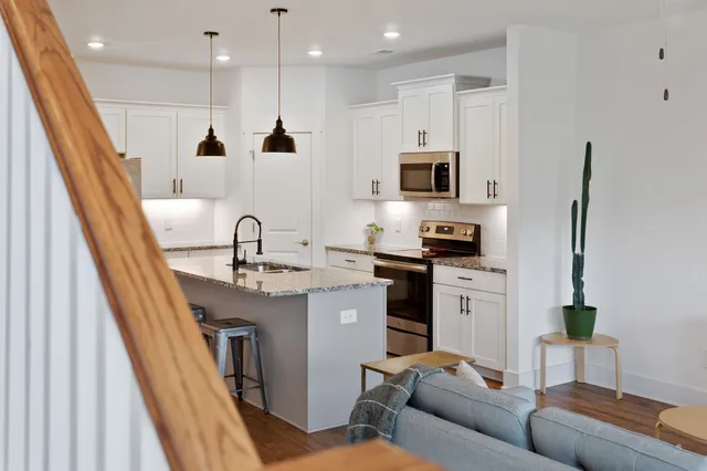 a kitchen with stainless steel appliances granite countertop a sink and a refrigerator