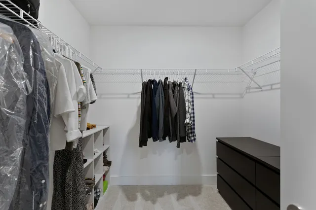a view of walk in closet with clothes and shoes