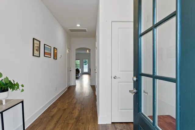 a view of a hallway with wooden floor and staircase