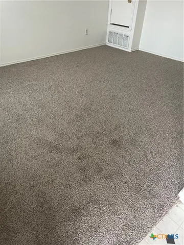 a view of a refrigerator in an empty room