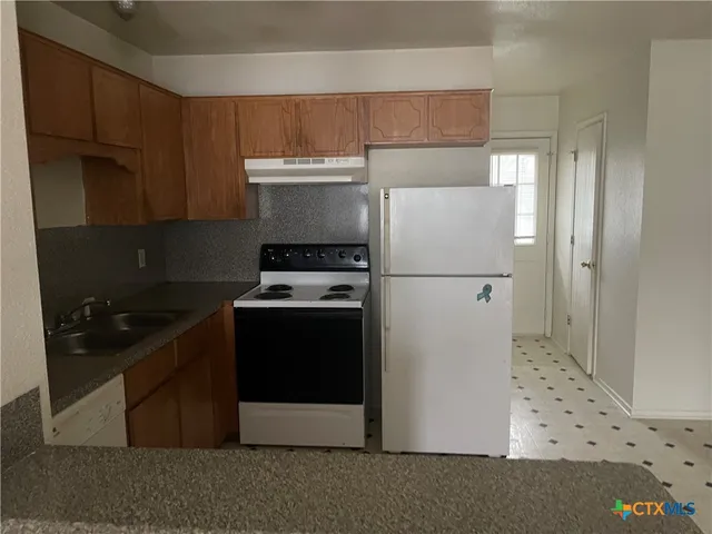 a kitchen with stainless steel appliances a refrigerator and a stove