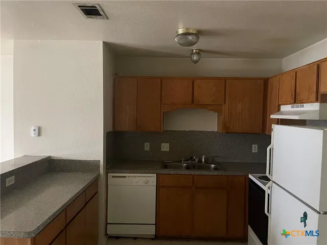 a kitchen with a sink and a refrigerator