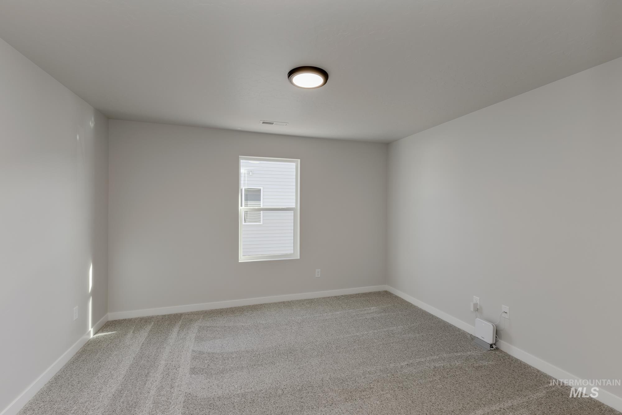 13337 Scrape Street Caldwell, ID 83607 - Photo 14 of 19 Recessed window with white trim, light gray wall paint, and gray patterned carpeting
