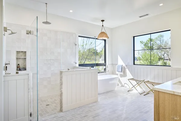 a bathroom with a granite countertop sink a large mirror and a bathtub