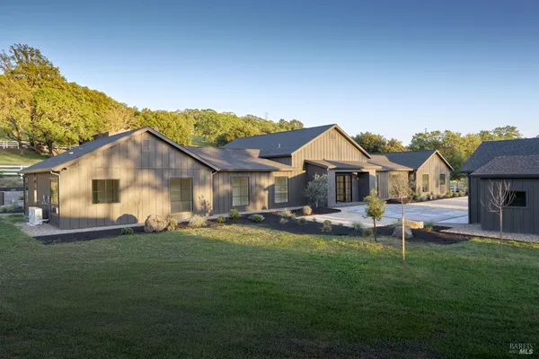 a view of a house with a big yard and sitting area