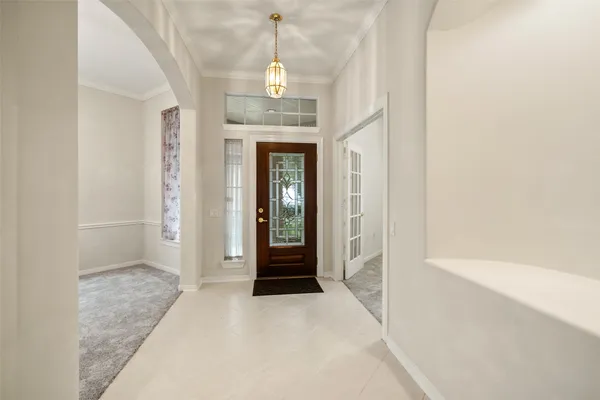 a view of a hallway with wooden floor and a chandelier