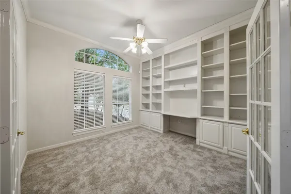 a view of an empty room with a window and a kitchen
